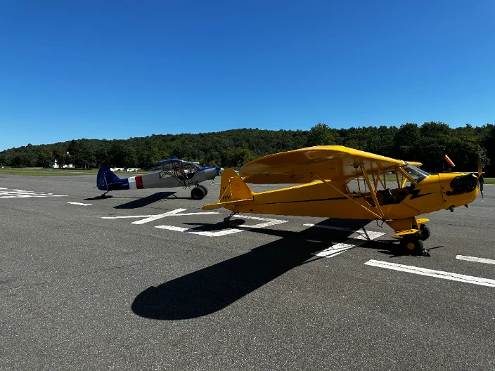 A yellow Piper Cub on the ramp