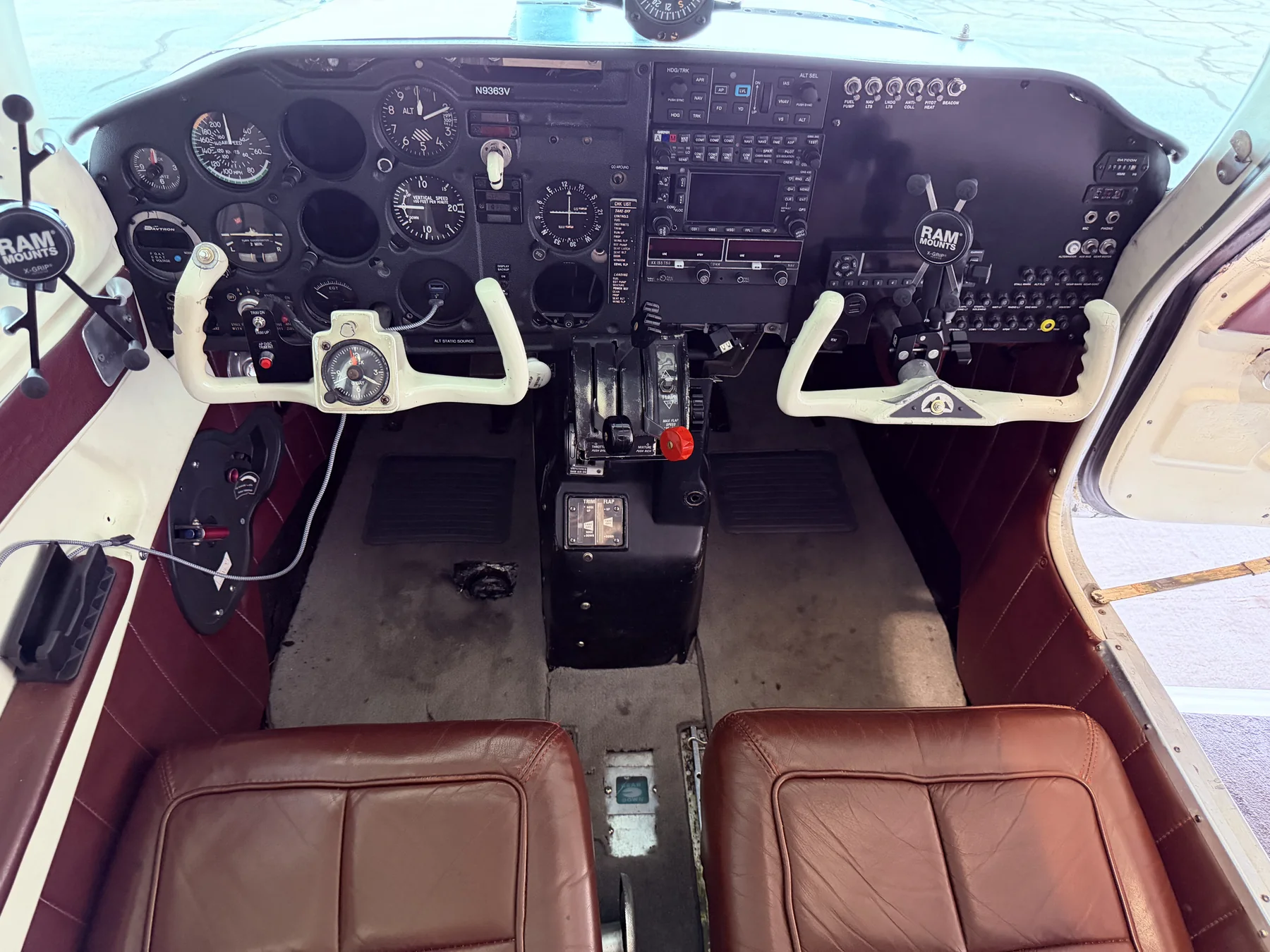 The N9363V cockpit from behind, showing both yokes, the throttle quadrant, front seats, and full panel